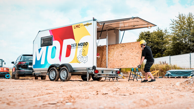 Ein Handwerker läd Baumaterial in den Humbaur MODO. | © Humbaur GmbH