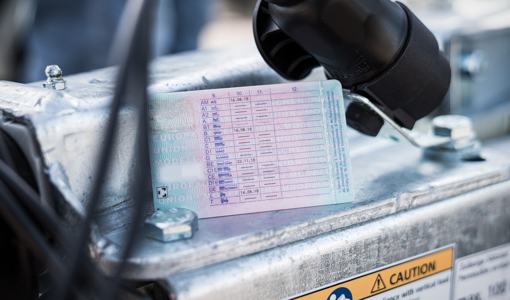 Auf einem Anhänger liegt ein Führerschein, dessen Rückseite zu sehen ist.  | © Humbaur GmbH